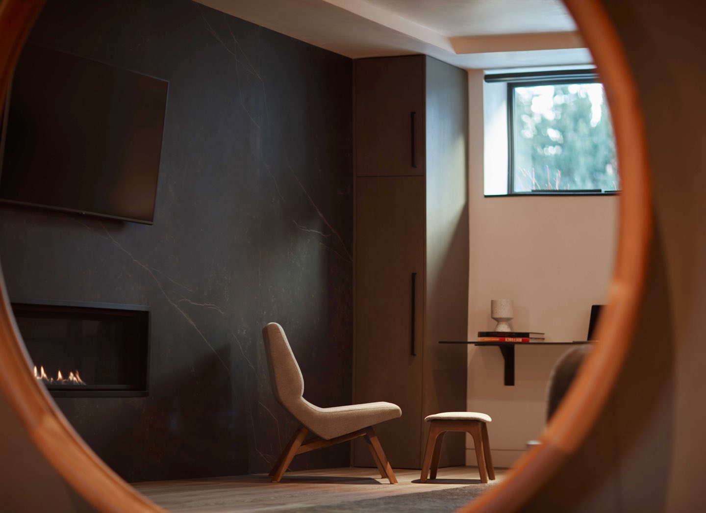 a modern chair and a fireplace photographed in a circular mirror
