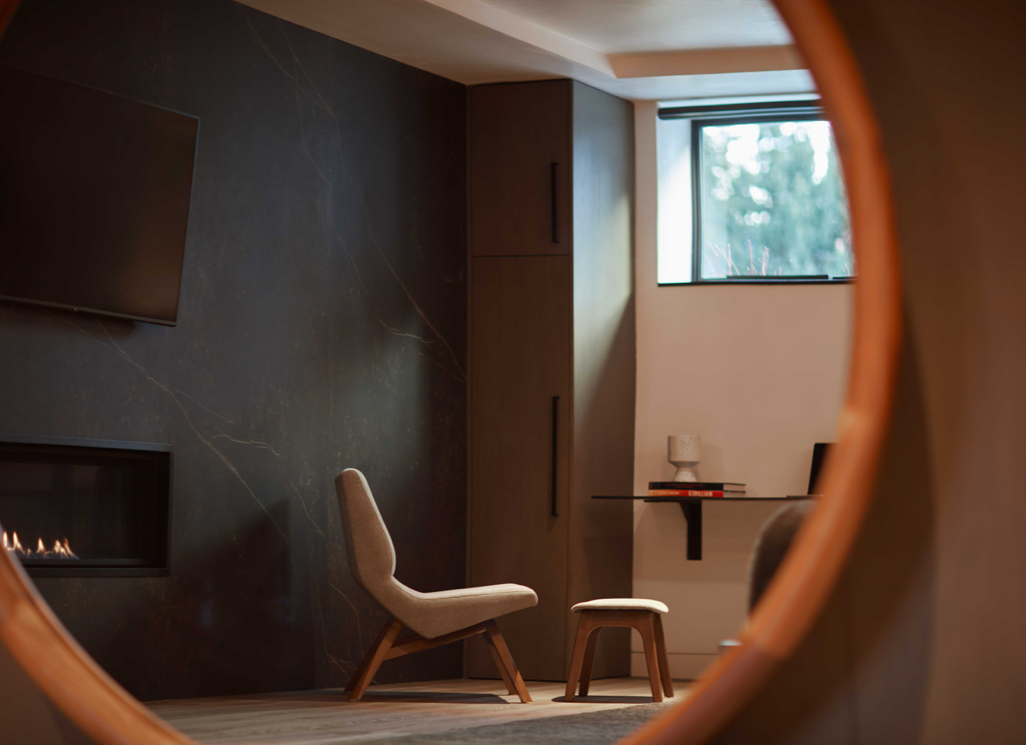 modern chair with a fireplace shot in the circular mirror