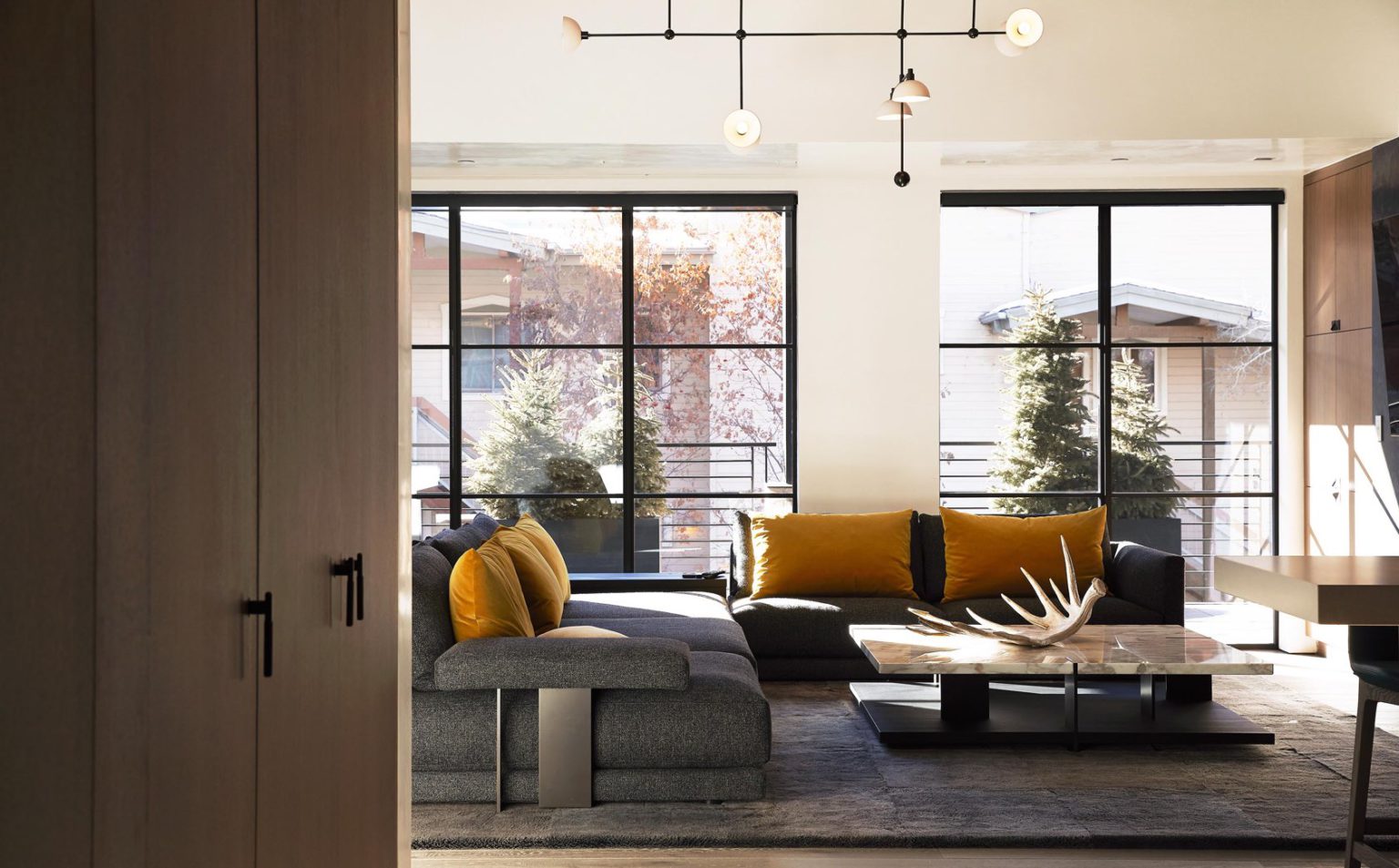 a charming, modern mountain chic living room with a grey couch, fireplace and yellow pillows