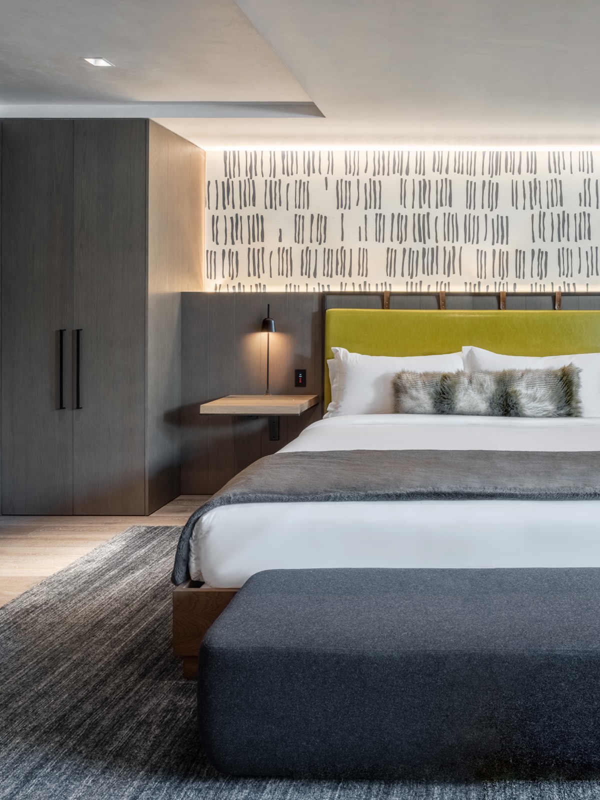 Luxury lodging bedroom in Aspen, CO with king bed, modern furniture and graphic wallpaper