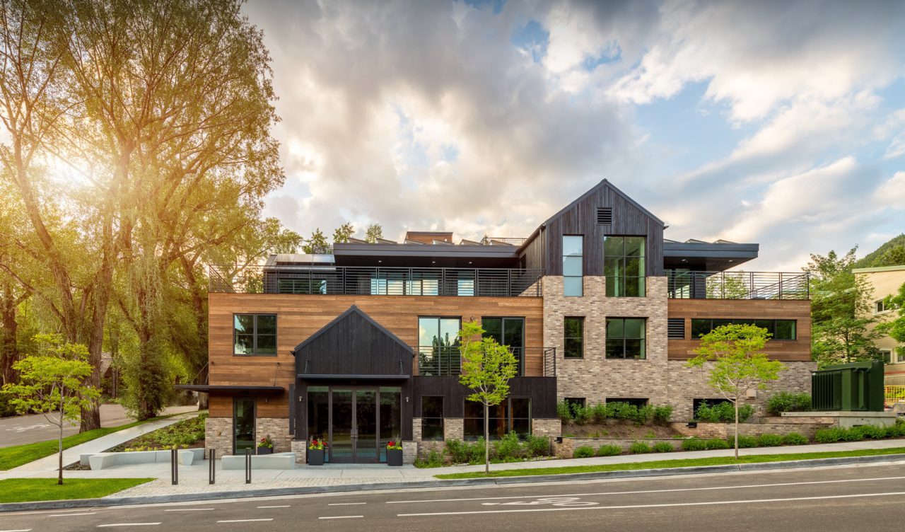 Exterior of Aspen Street Lodge with mountain modern facade, large trees and sidewalk