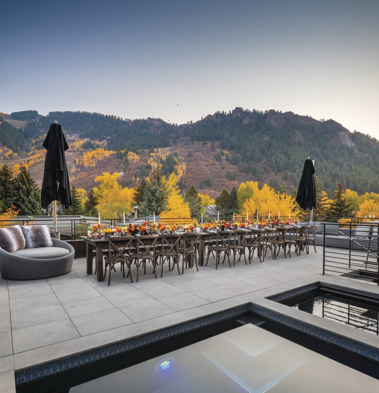 pool with mountain backdrop in the fall of aspen colorado with a table set in the middle
