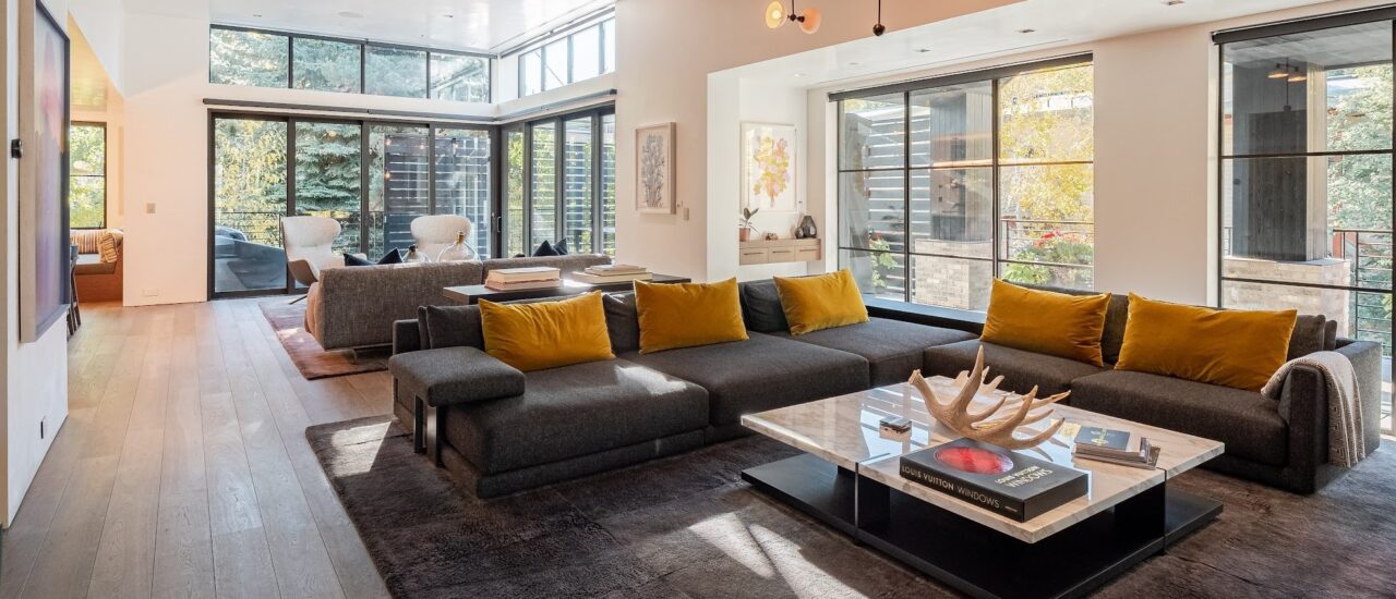 Living room with couches, wall mounted tv, gas fireplace and wet bar at downtown Aspen lodge